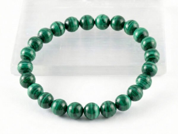 Authentic Malachite stone bracelet resting on a white display plate.
