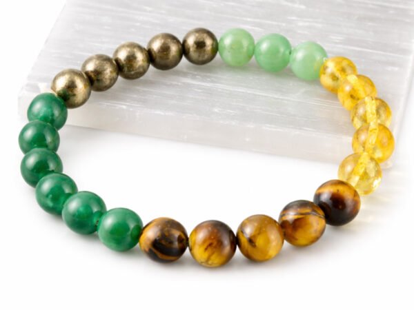 Authentic multi-color Money Magnet stone bracelet resting on a white display plate.