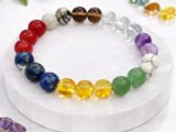 Authentic multi-color Navratna 9 Garah stone bracelet resting on a white textured display plate.