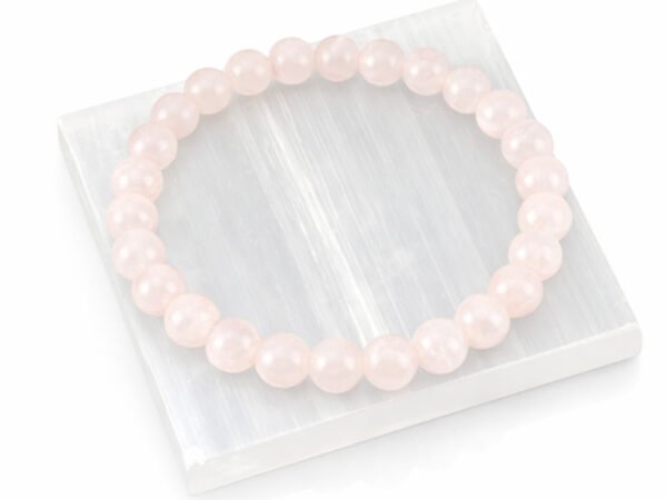Authentic natural Rose Quartz gemstone bracelet resting flat on a square white textured display plate.