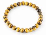 Natural yellow Tiger Eye 8mm round bead bracelet isolated on a plain white background.