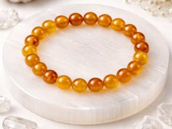 Authentic natural Yamini Hakik Yellow Agate gemstone bracelet resting flat on a round white display plate.
