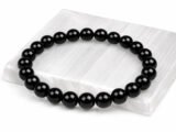 Authentic natural Black Quartz gemstone bracelet resting flat on a white square textured display plate.