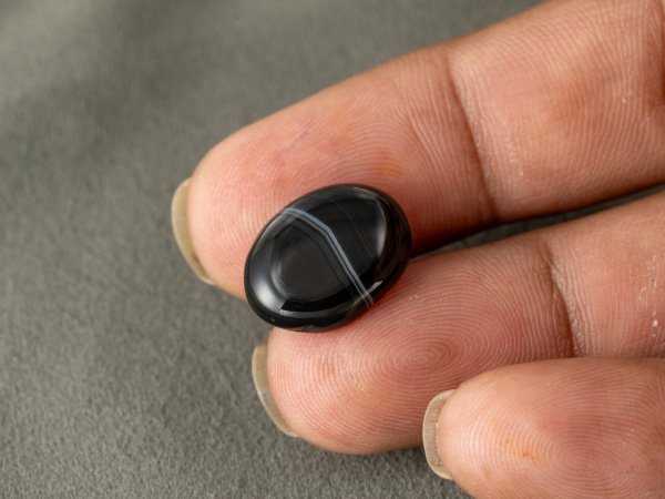 Sulemani Hakik 7.66 Carat in-hand size reference 17.5 x 13.2 mm