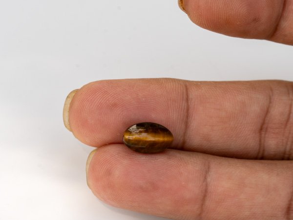 natural tiger eye stone 4.93 carat in hand size reference