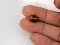 natural tiger eye stone 6.77 carat in hand size reference