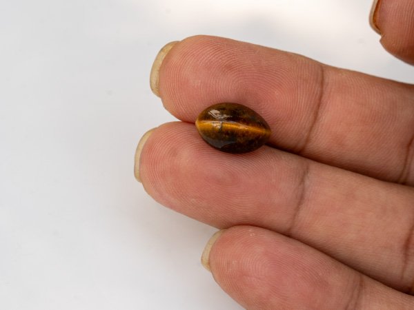 natural tiger eye stone 6.77 carat in hand size reference