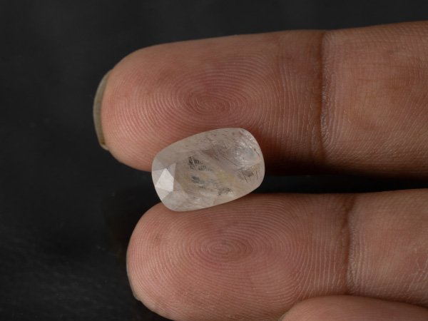natural white sapphire Safed Pukhraj 8.08 carat in hand scale